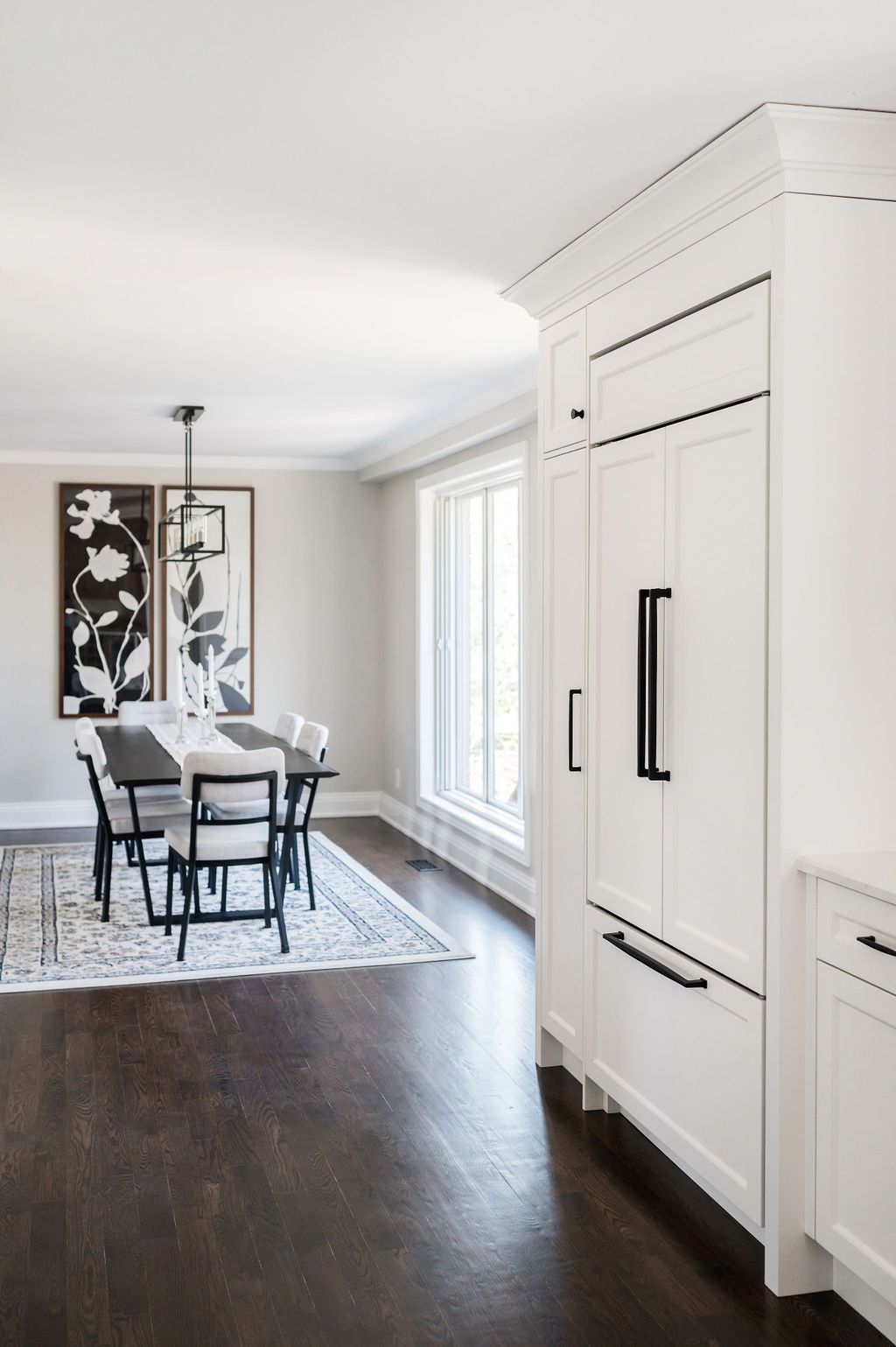 A dining room with a table and chairs and a refrigerator