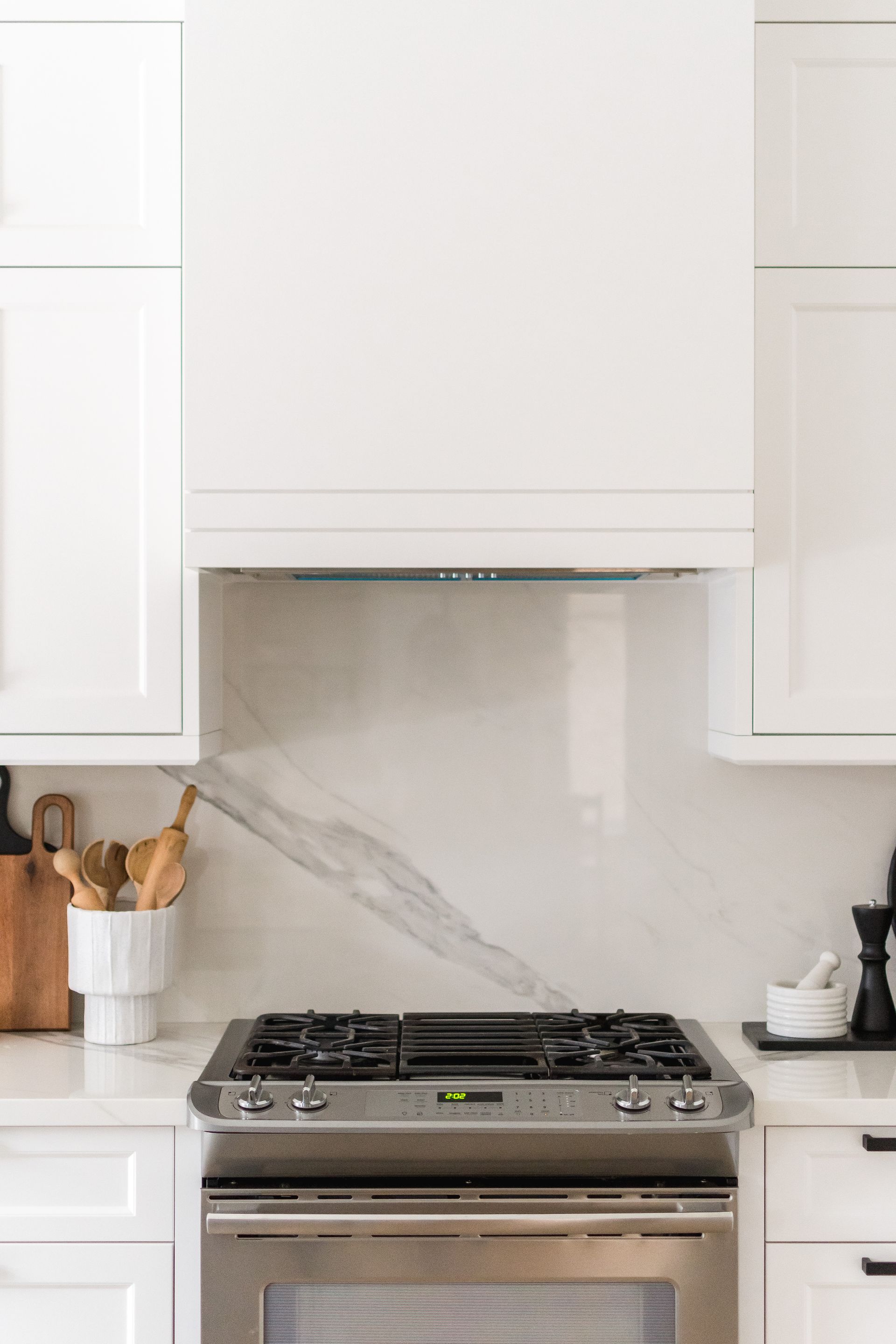A stove and oven in a kitchen with white cabinets.