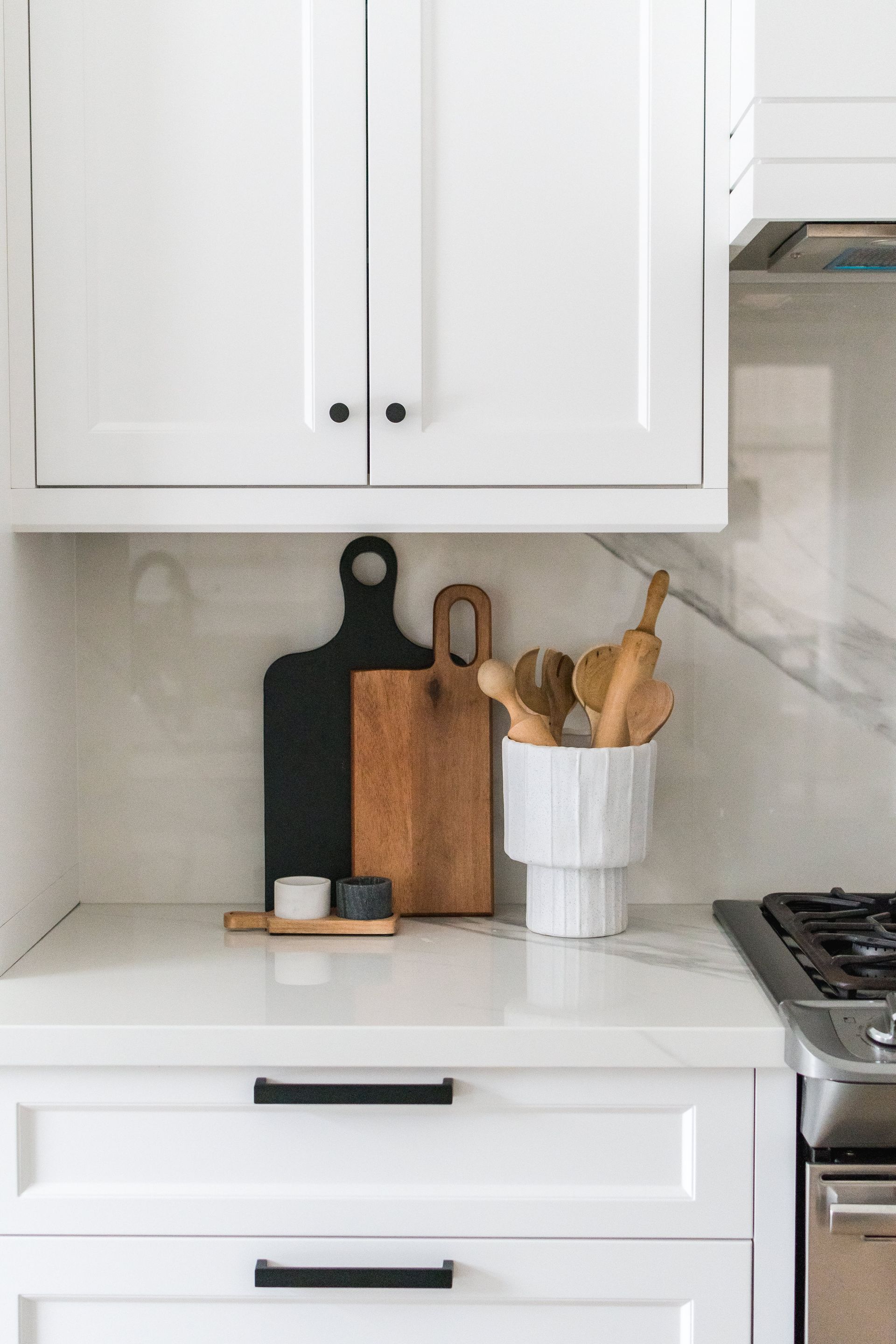 A kitchen counter with cutting boards and utensils on it.