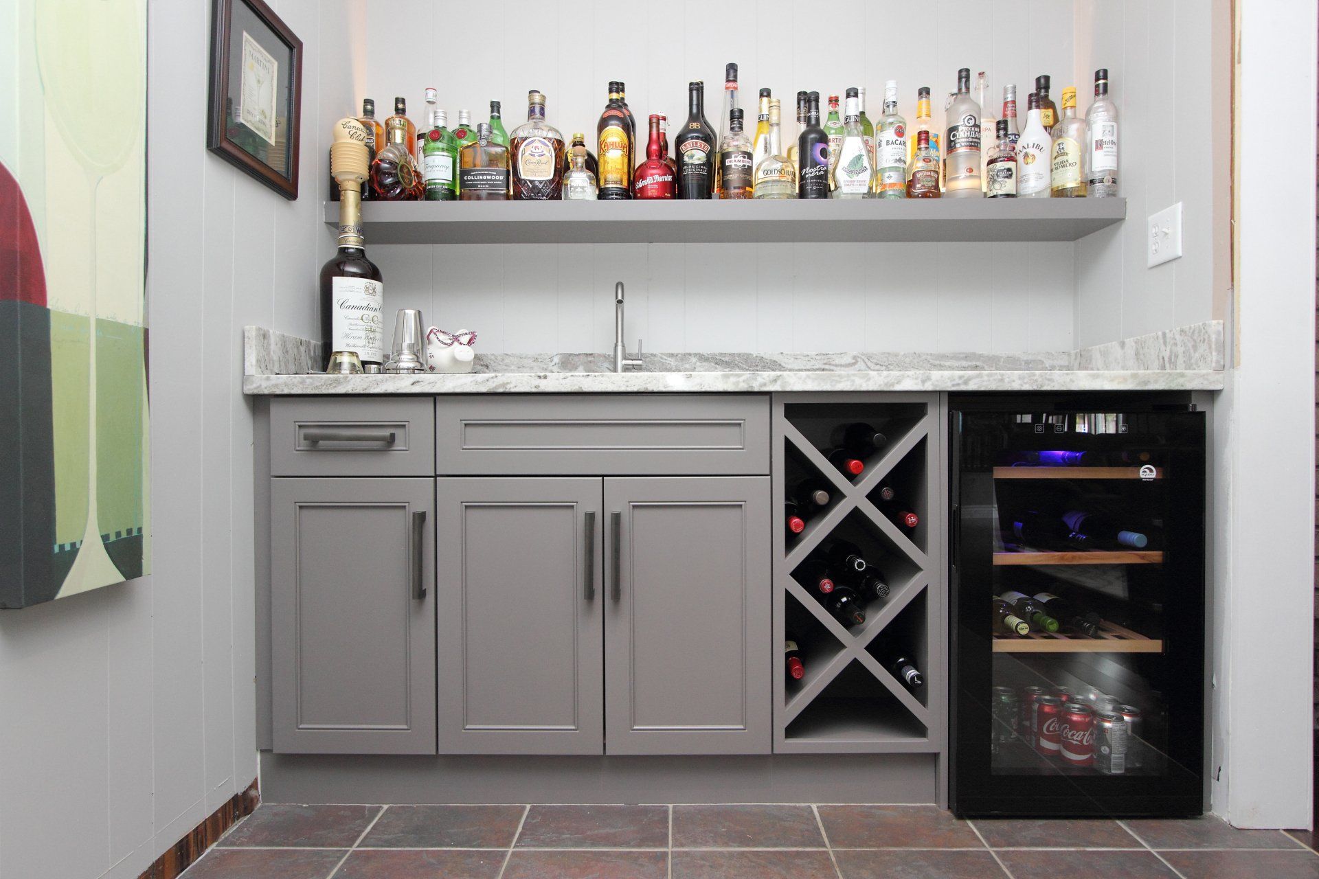 There are many bottles of alcohol on the shelves in this kitchen.