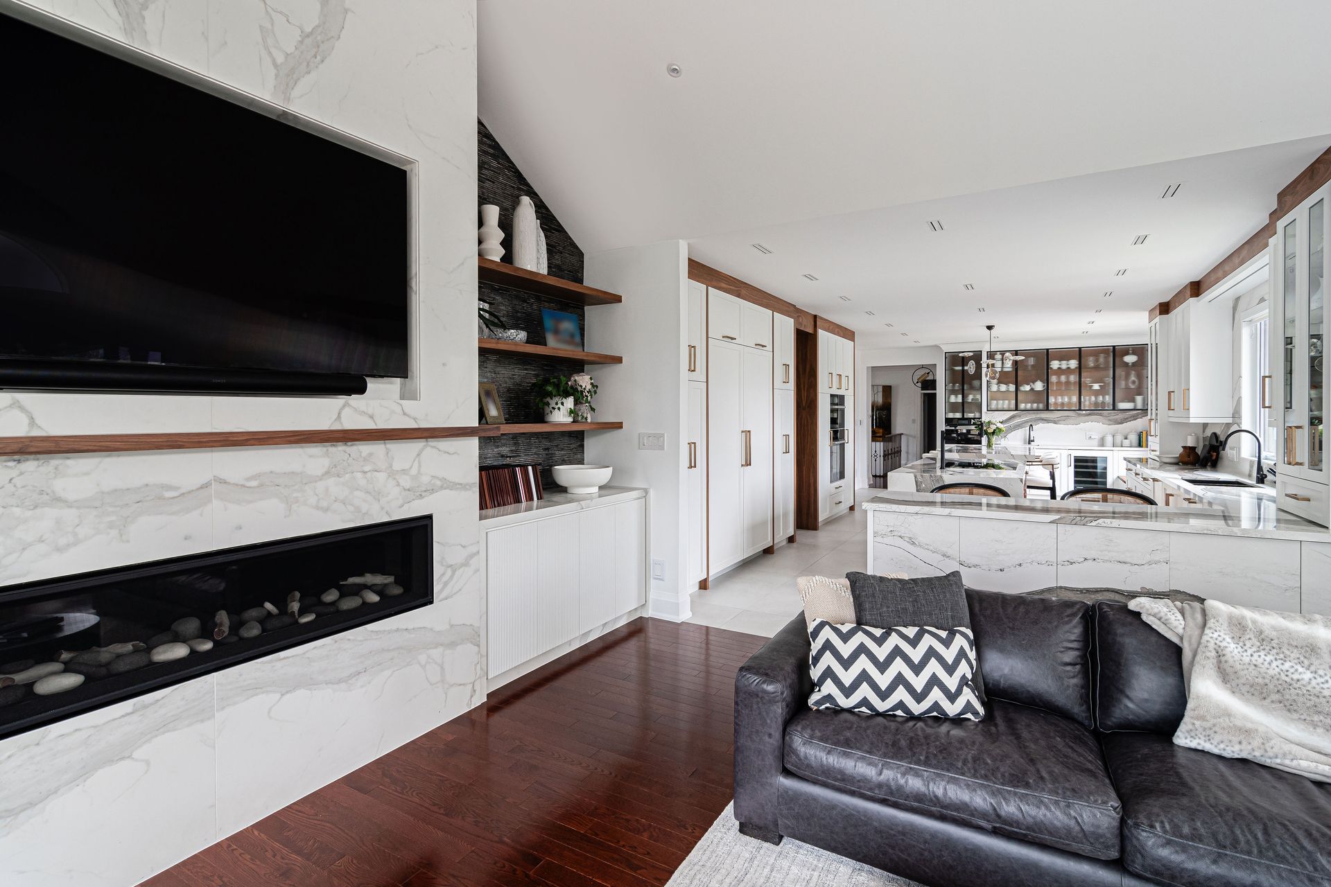 A living room with a black couch and a flat screen tv.