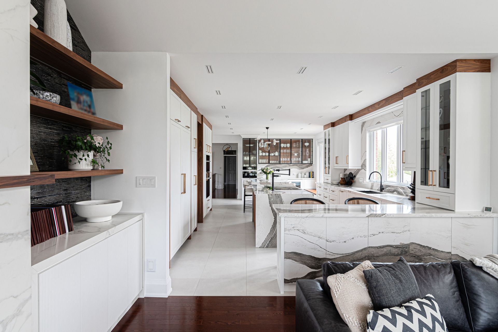 A living room with a couch and a kitchen in the background.