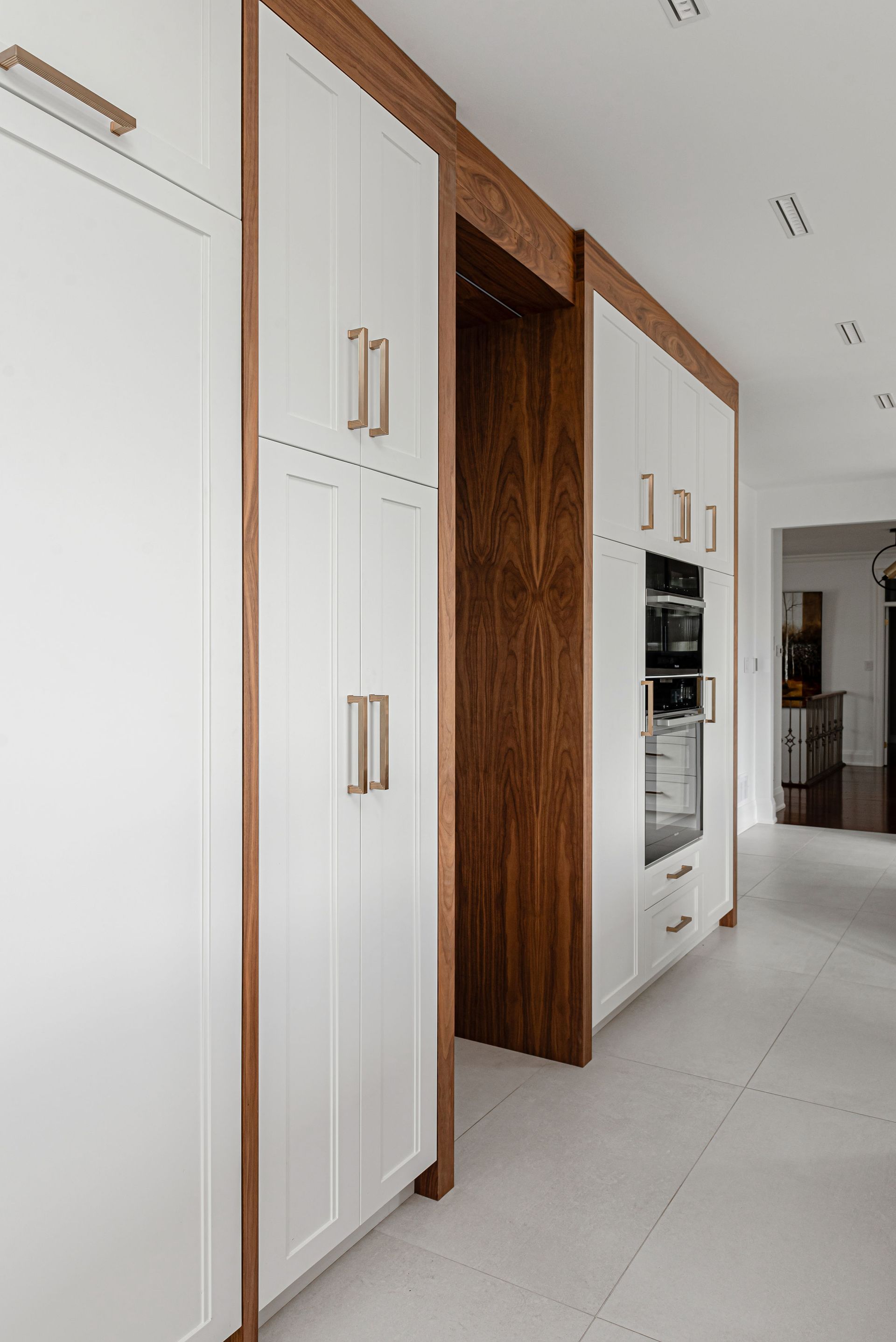 A kitchen with white cabinets and wooden trim