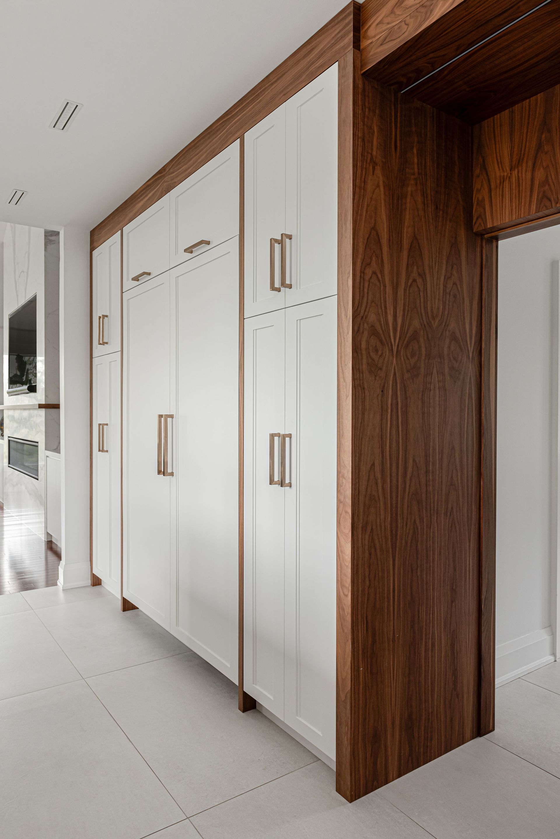 A kitchen with white cabinets and a wooden door.
