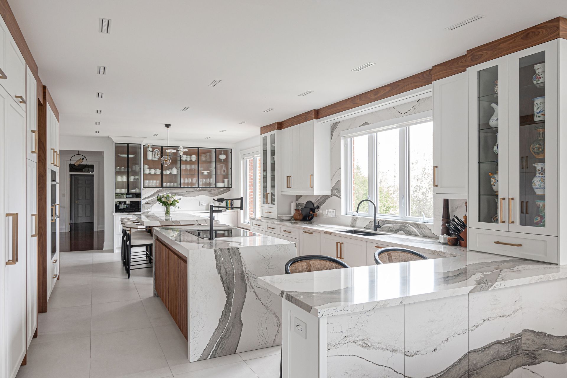 A large kitchen with white cabinets and marble counter tops.