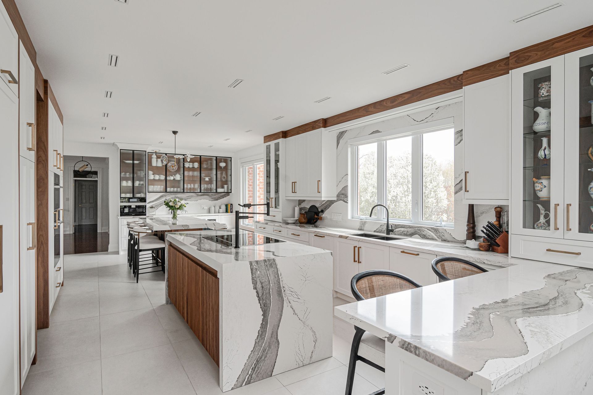 A large kitchen with white cabinets and marble counter tops.