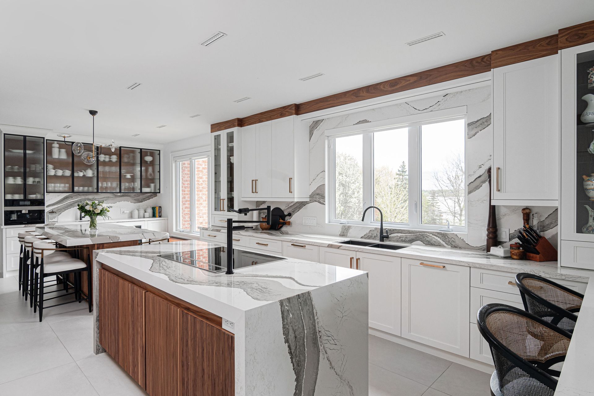 A kitchen with white cabinets and a large island in the middle.