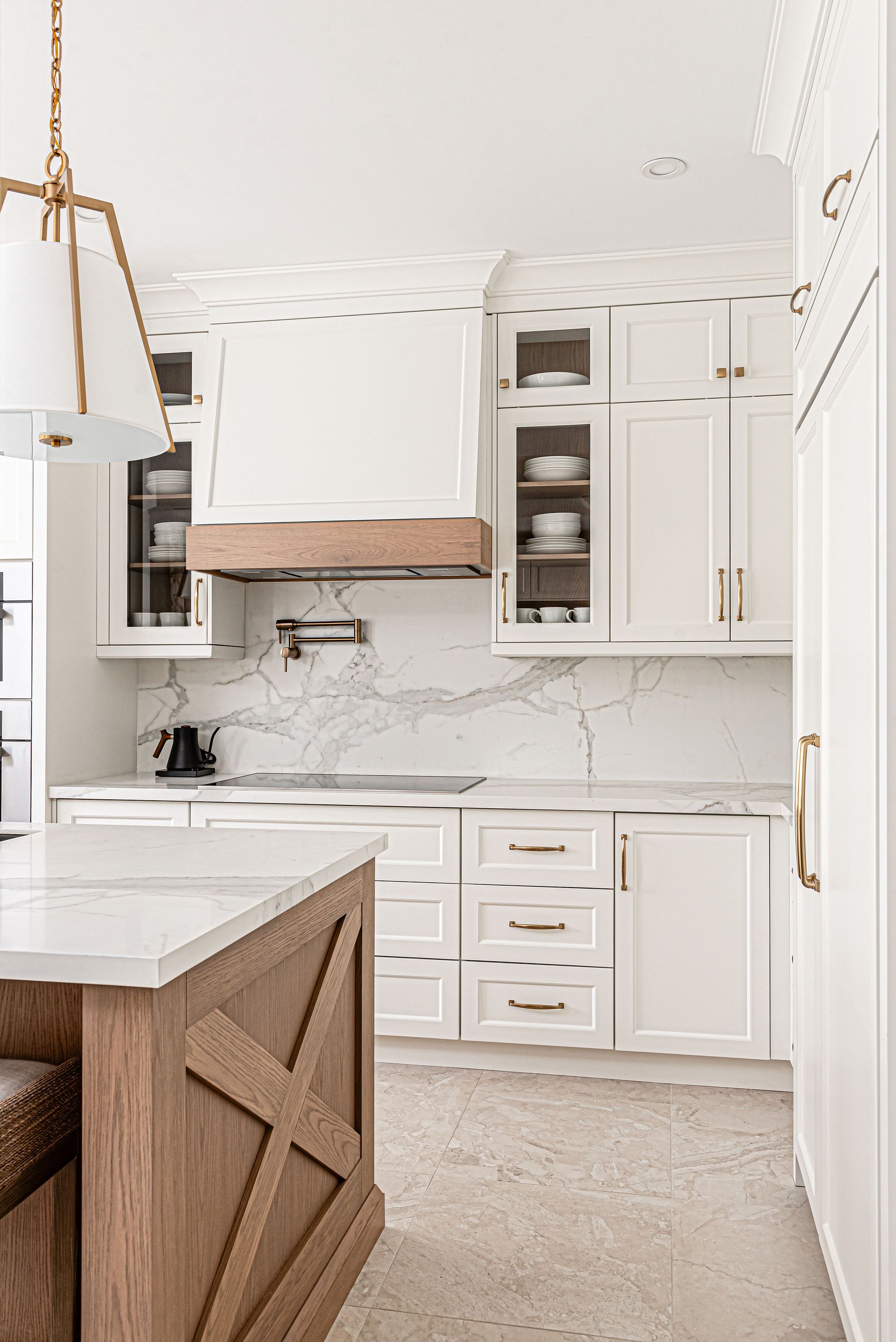 A kitchen with white cabinets and a wooden island.