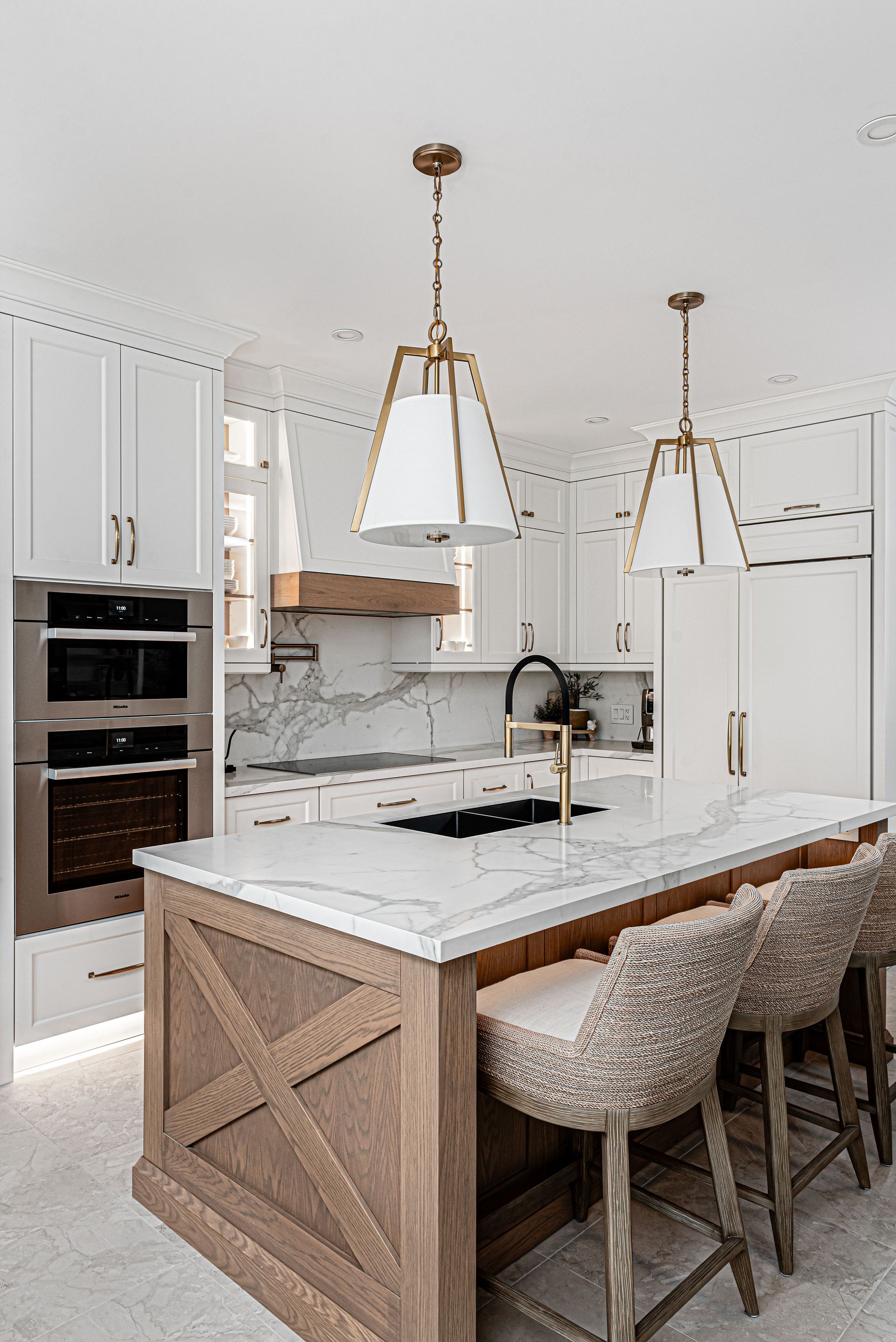 A kitchen with white cabinets , marble counter tops , stainless steel appliances , and a large island.