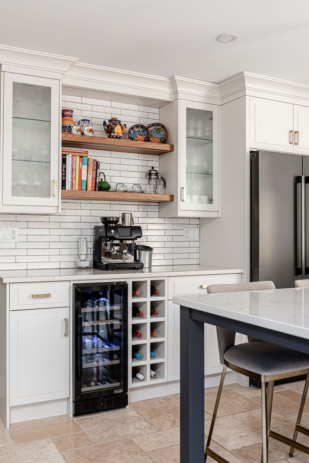 A kitchen with white cabinets , stainless steel appliances , a wine cooler and a coffee maker.