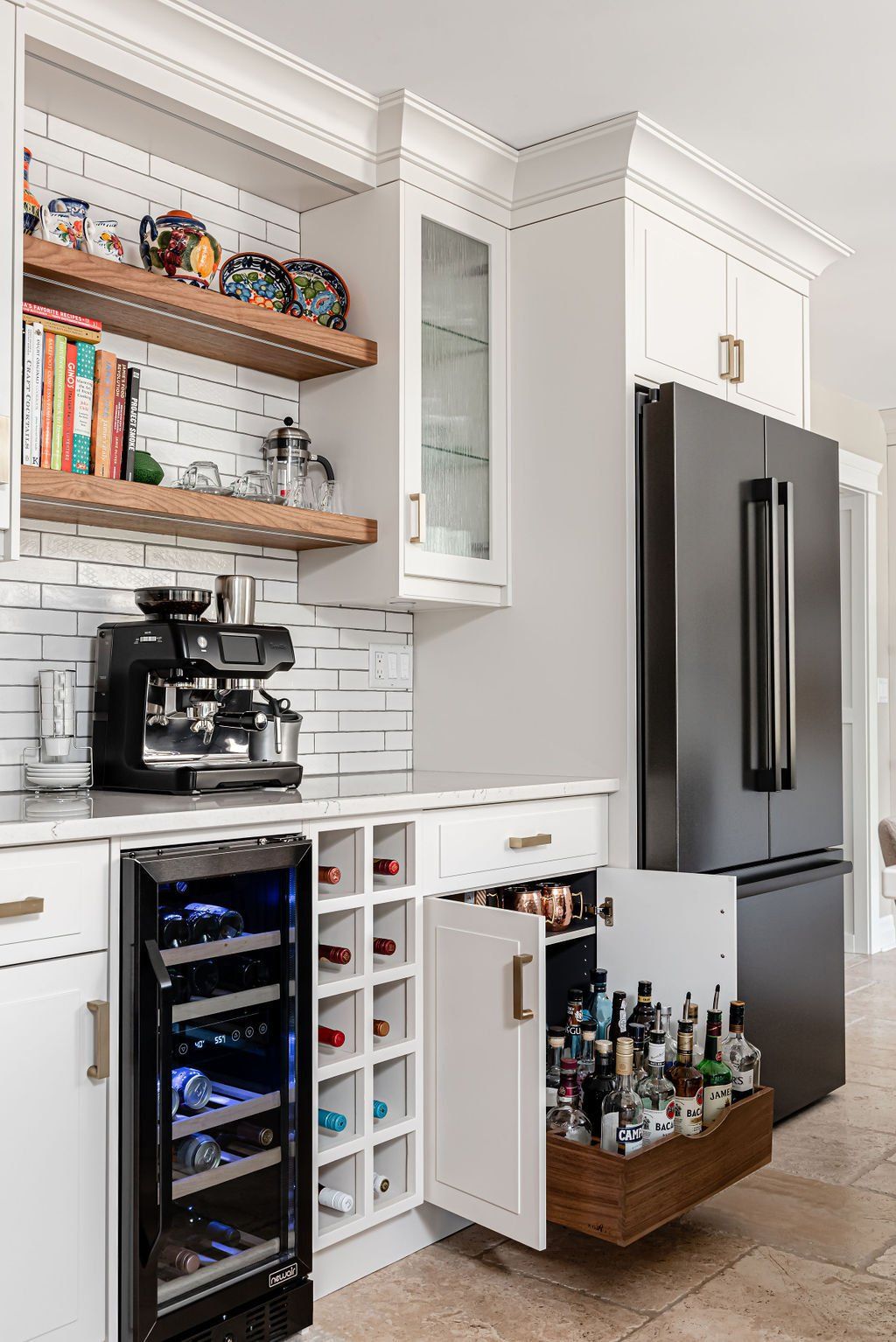 A kitchen with white cabinets , a black refrigerator and a wine cooler.