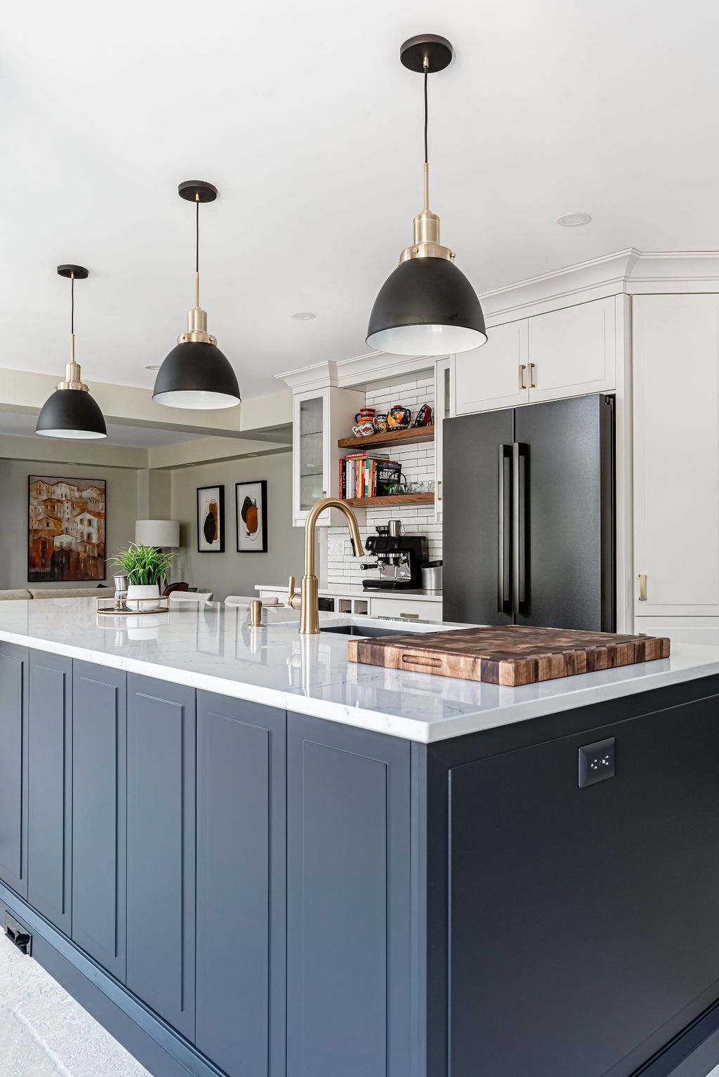 A kitchen with a large island and a black refrigerator.