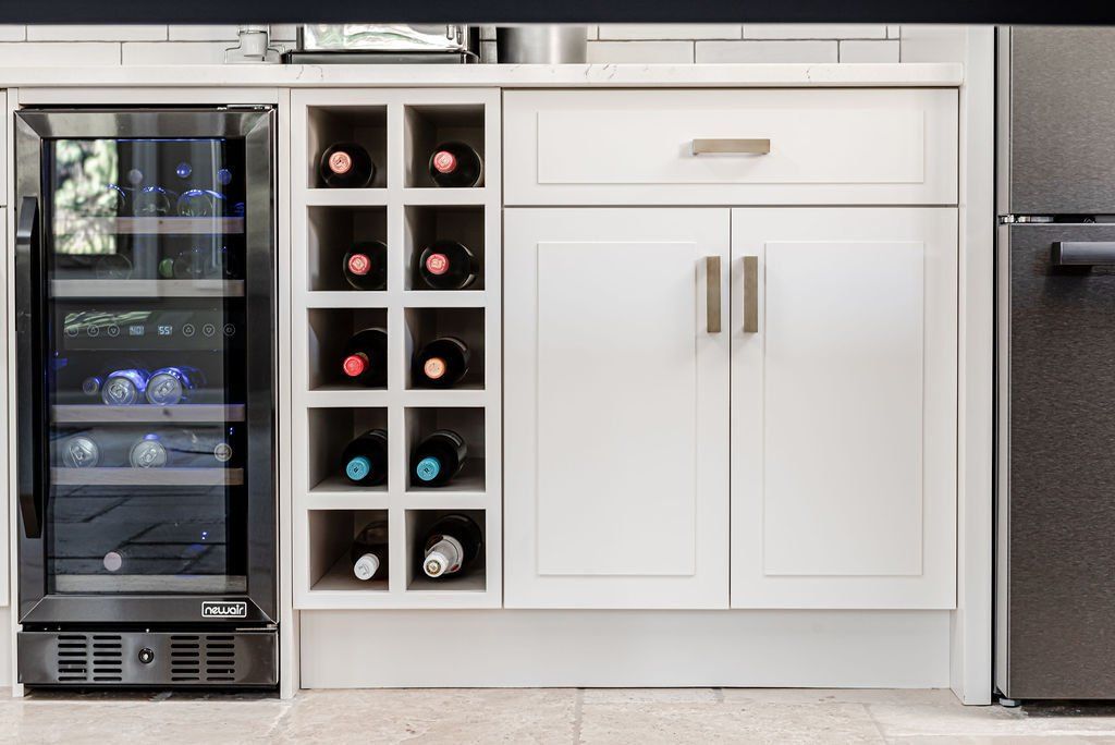 A kitchen with a wine cooler and a wine rack.