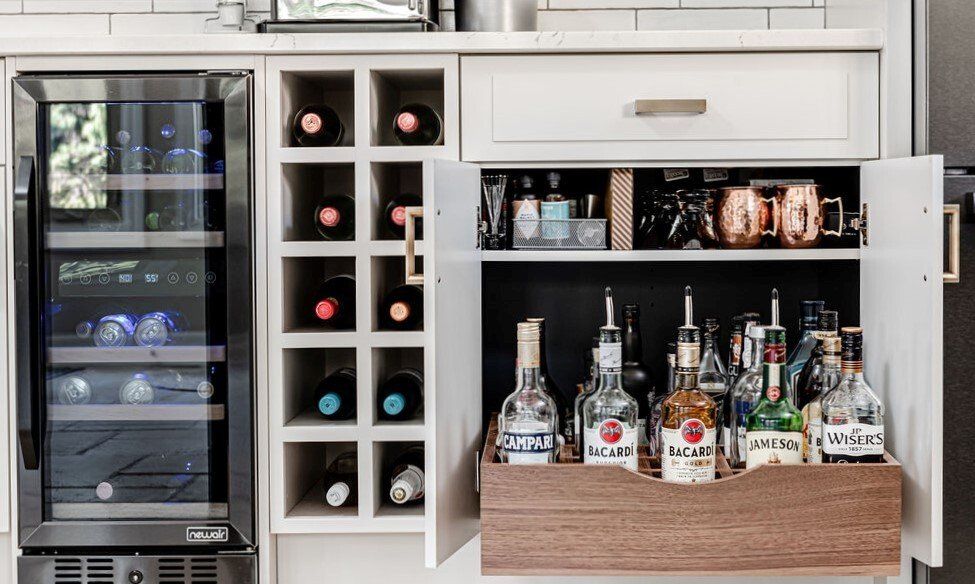A kitchen with a wine rack and a bar with bottles of liquor.