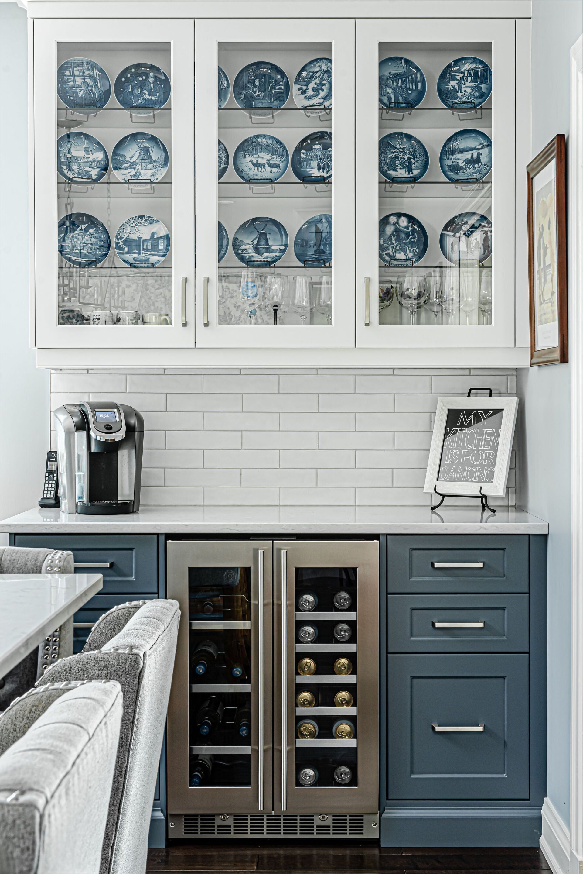 A kitchen with blue and white plates and a wine cooler.