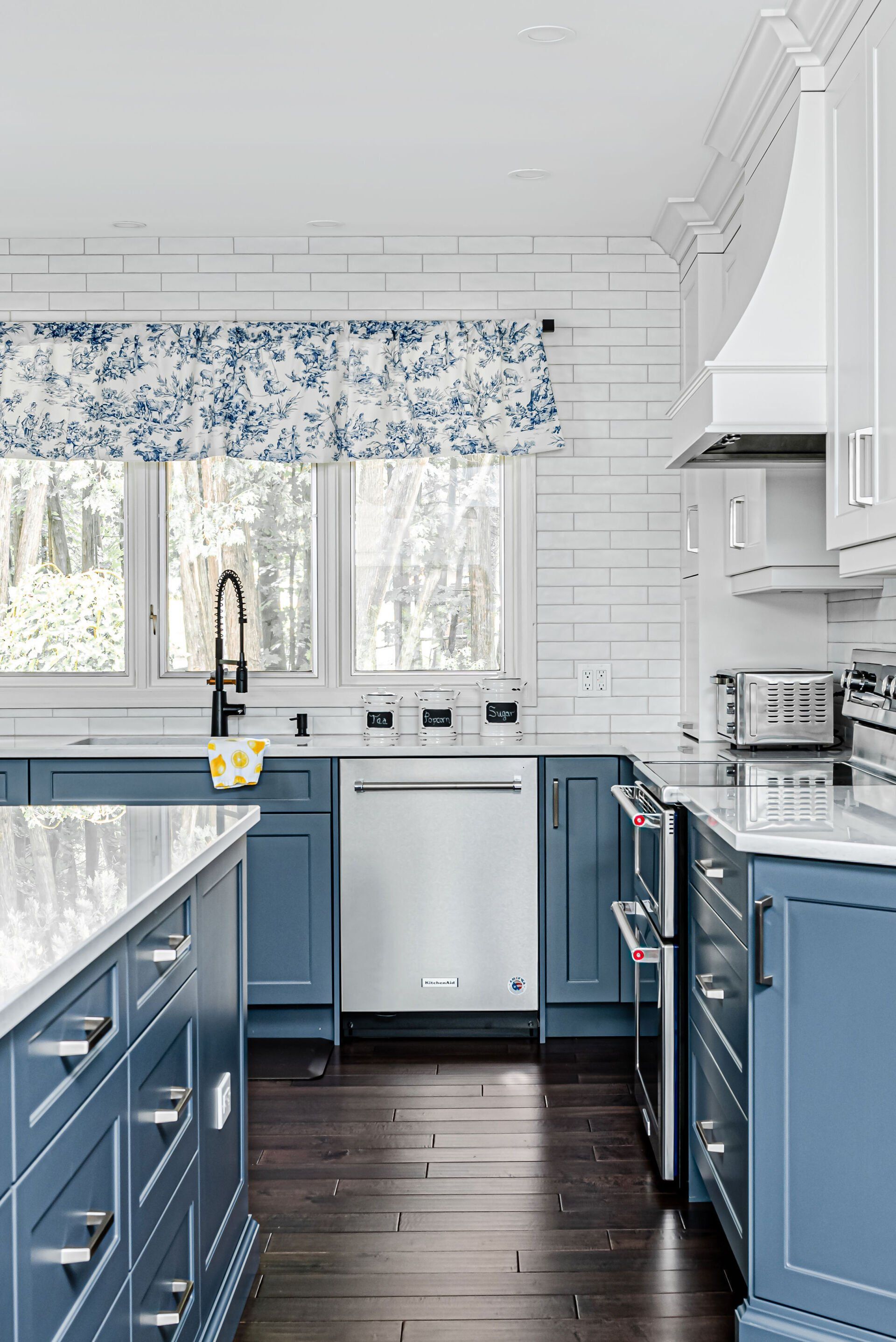 A kitchen with blue cabinets and white appliances.