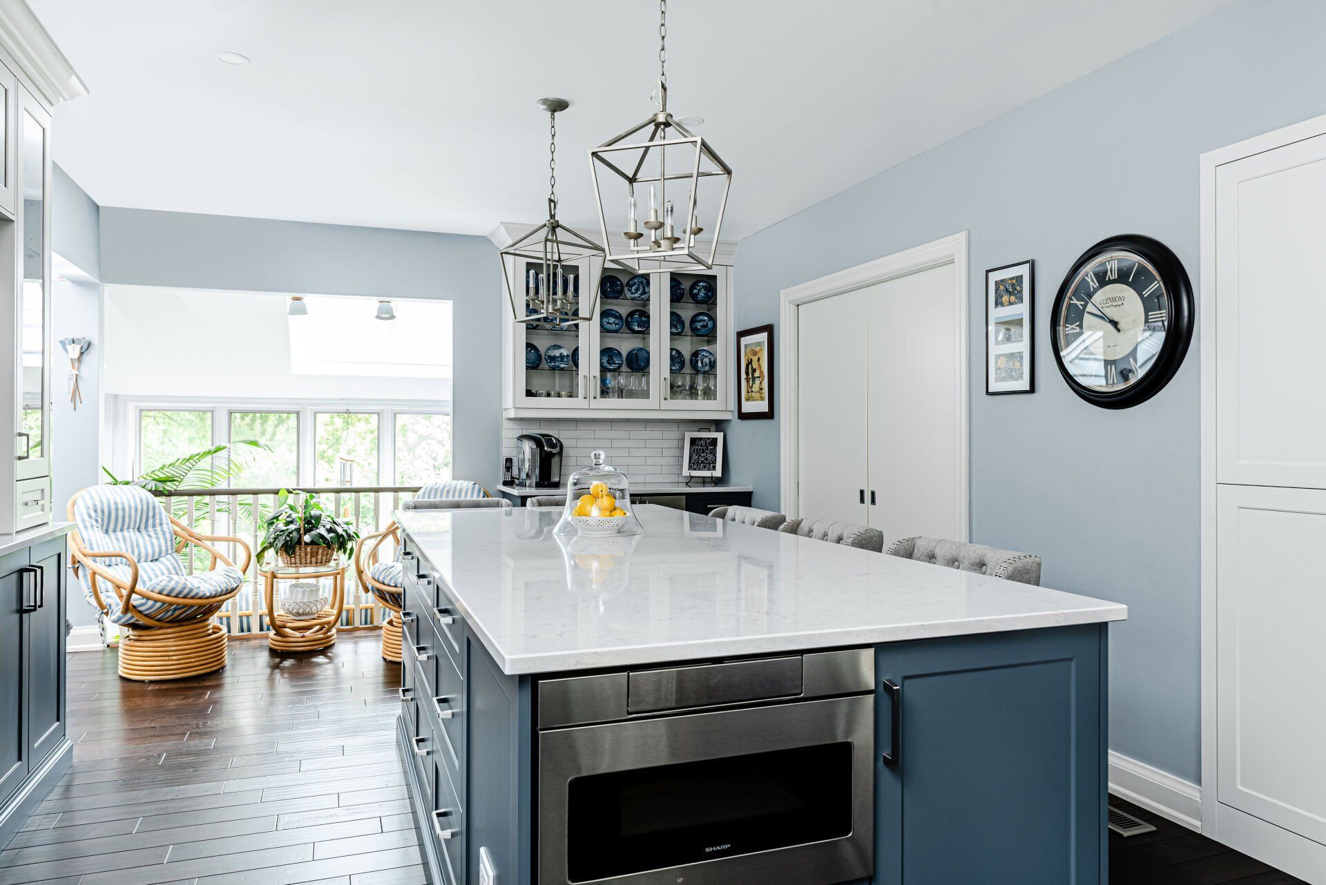 A kitchen with a large island and a clock on the wall.