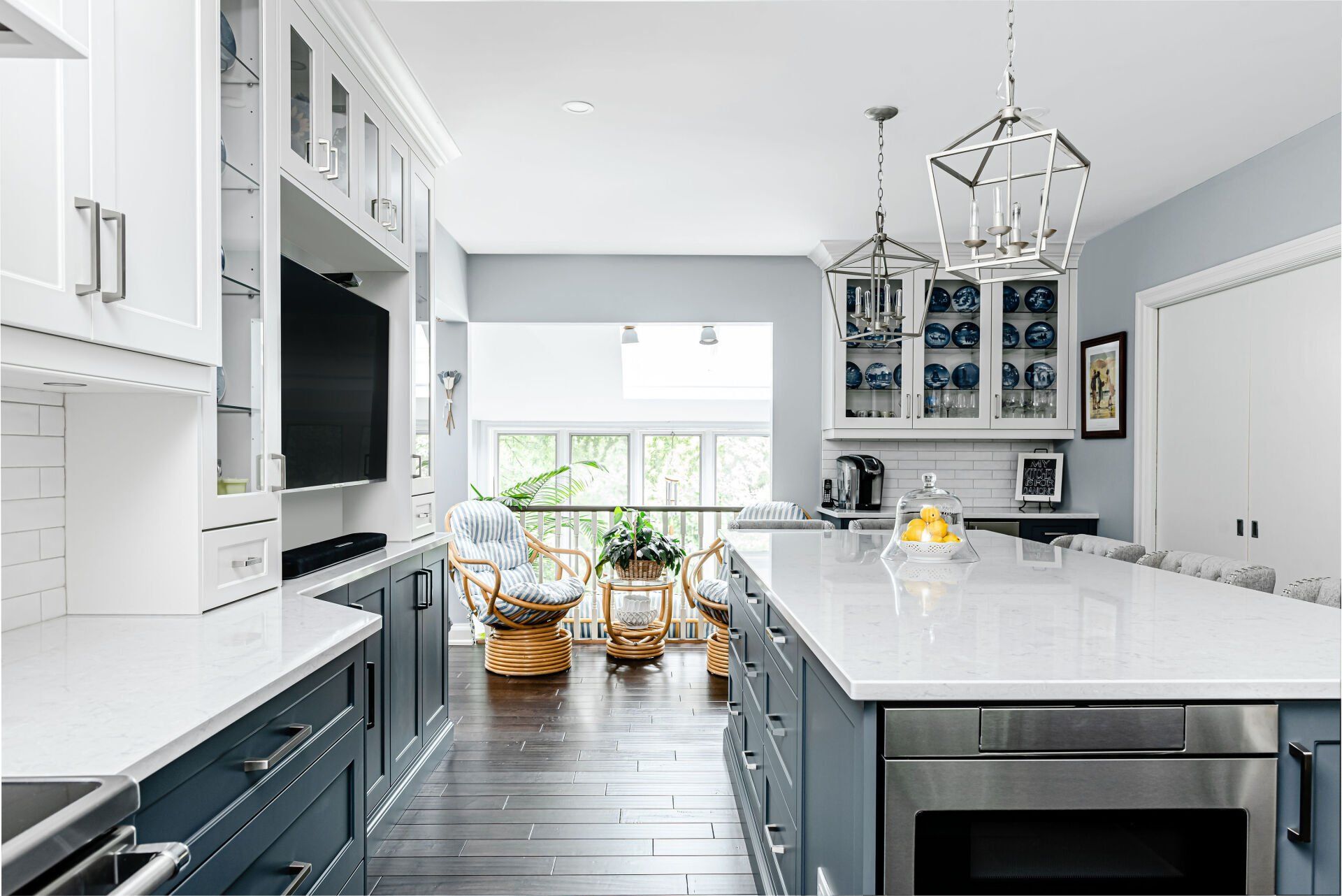A kitchen with blue cabinets , white counter tops , stainless steel appliances and a large island.