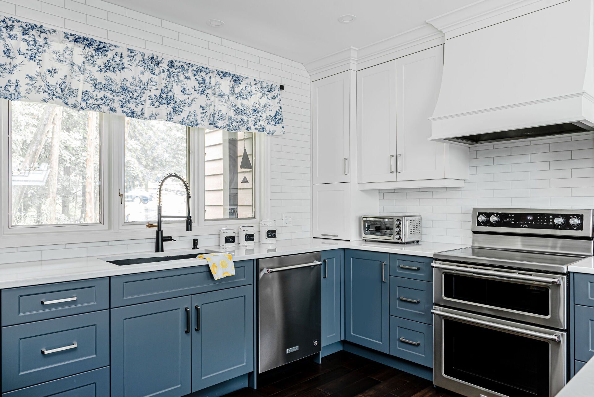 A kitchen with blue cabinets and stainless steel appliances.