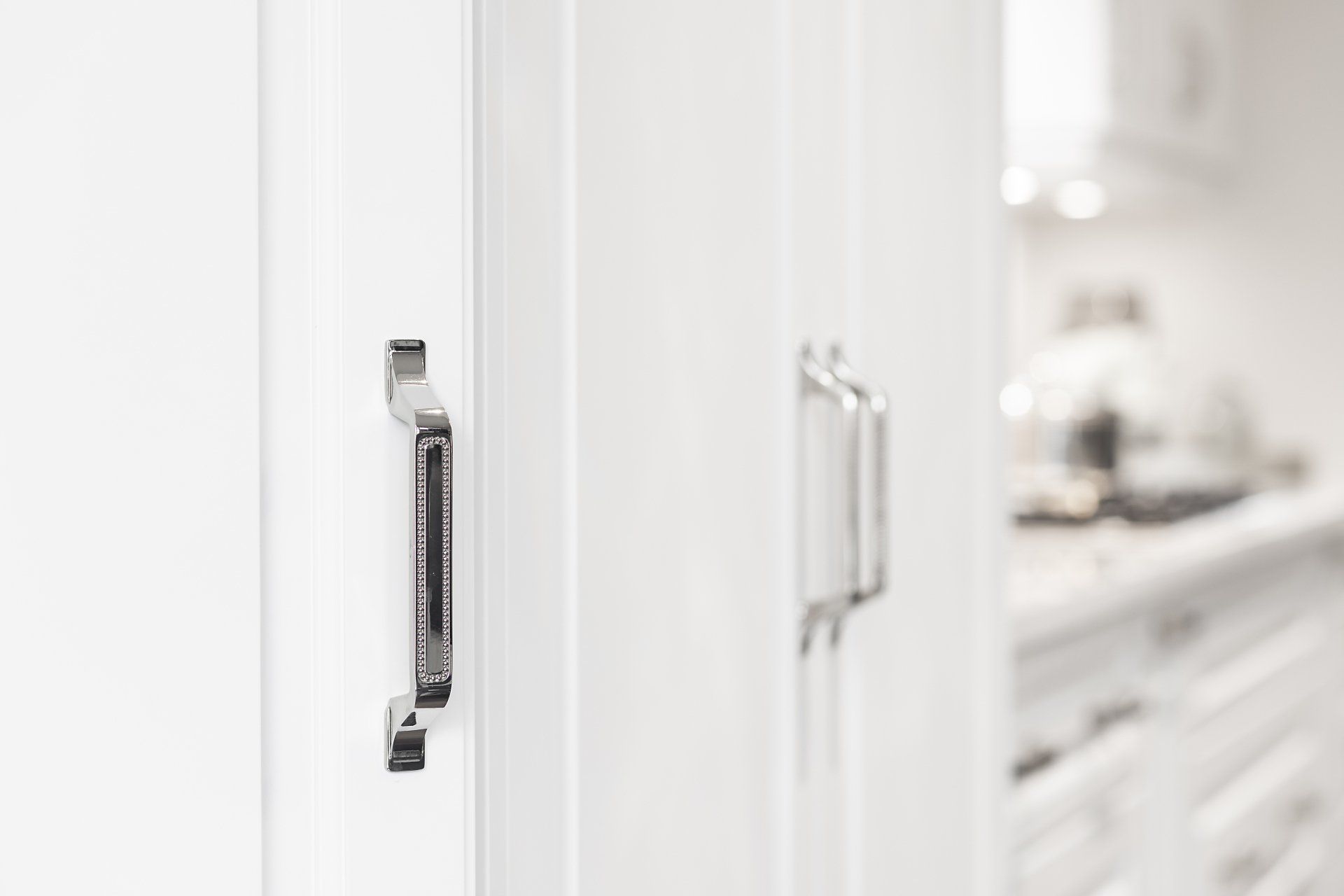 A close up of a door with a handle in a kitchen.