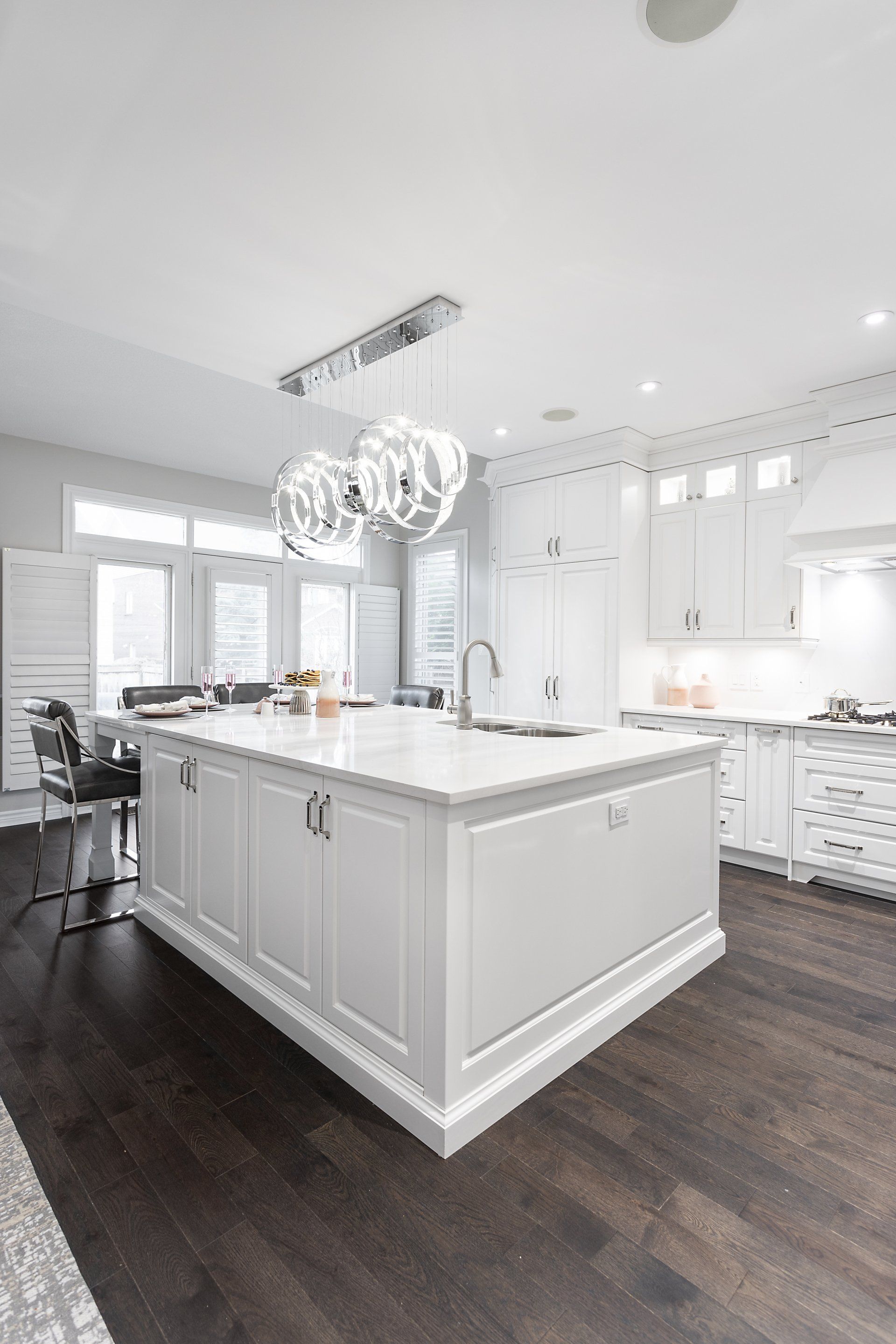 A kitchen with white cabinets and a large island in the middle.