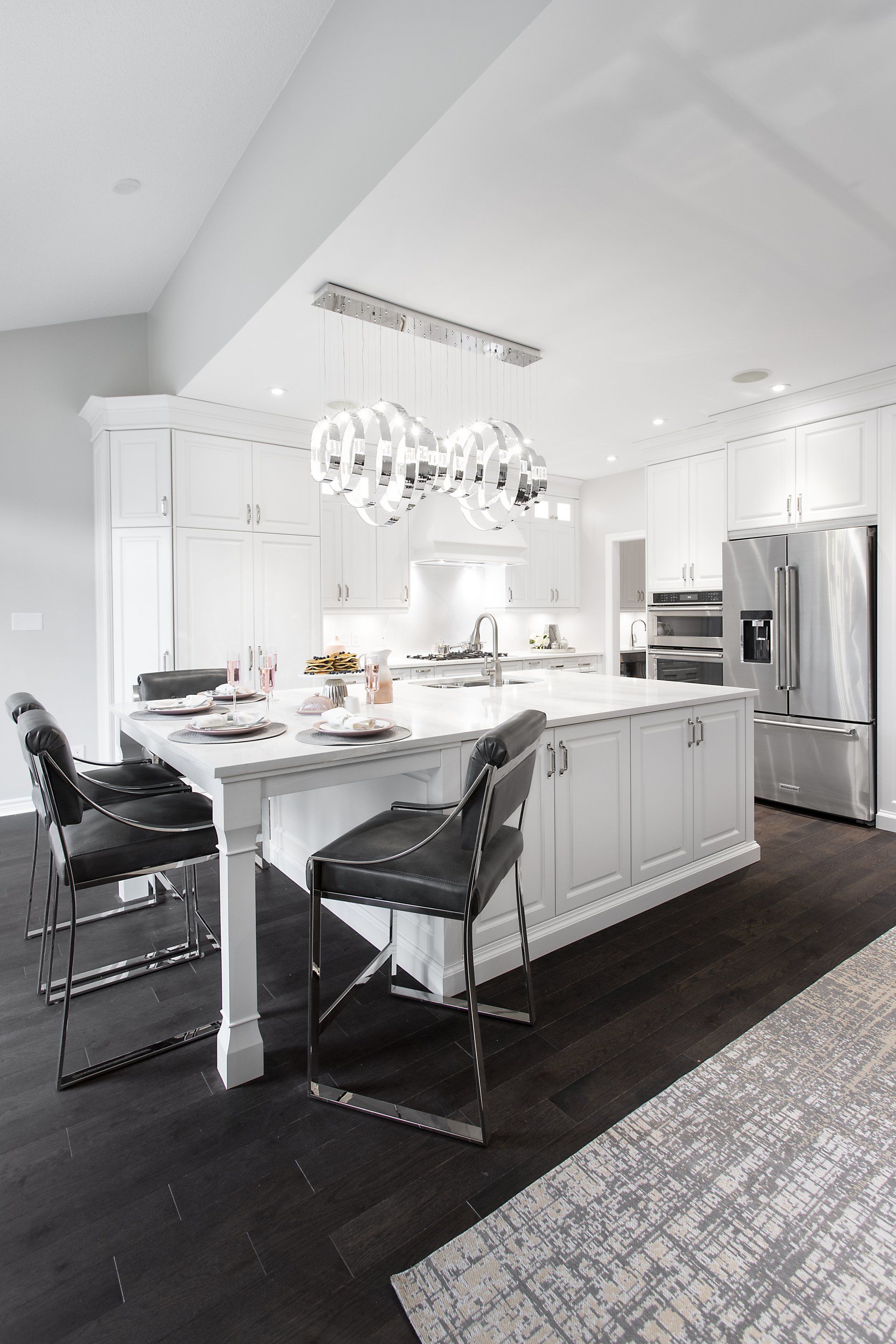A kitchen with white cabinets and stainless steel appliances and a large island.