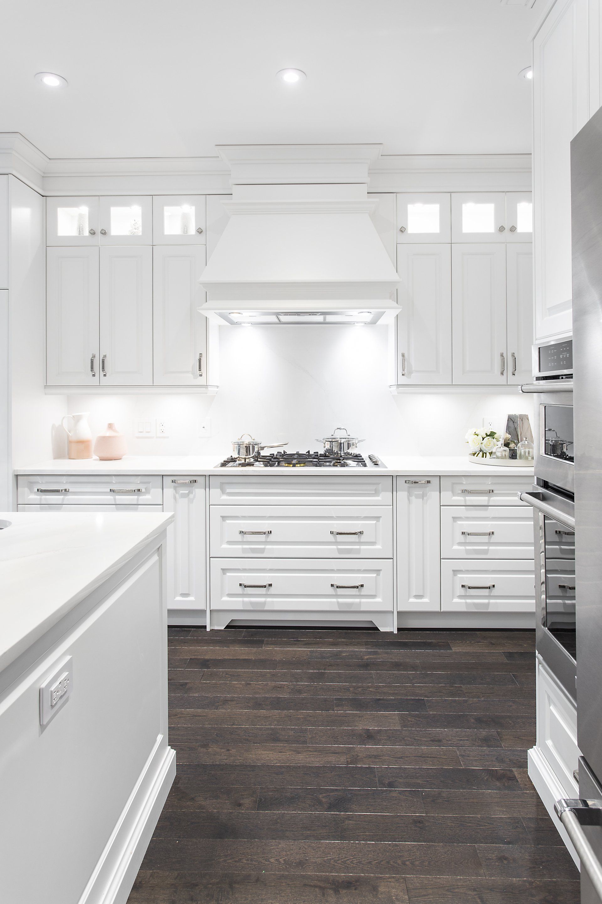 A kitchen with white cabinets and stainless steel appliances.