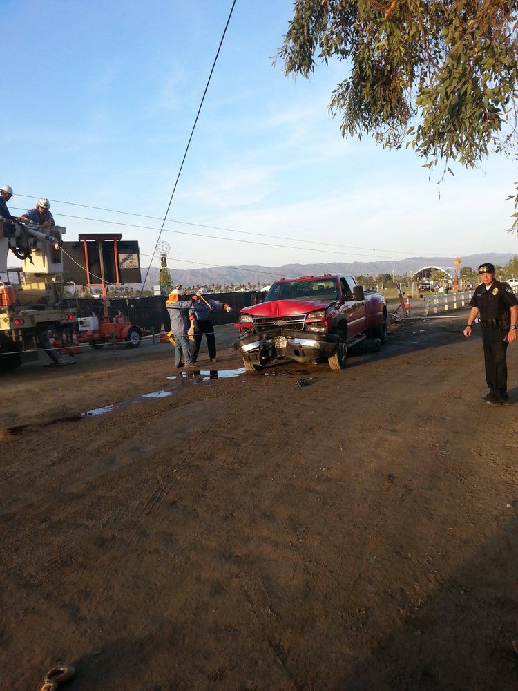 A red truck is being towed by a tow truck