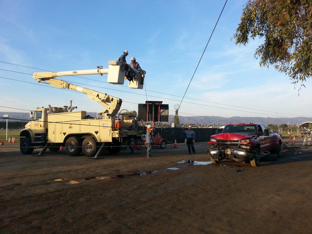 A red truck is parked next to a utility truck