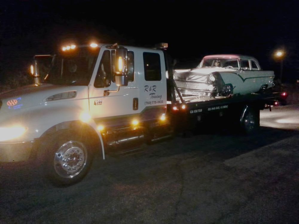 A tow truck with a car on the back of it