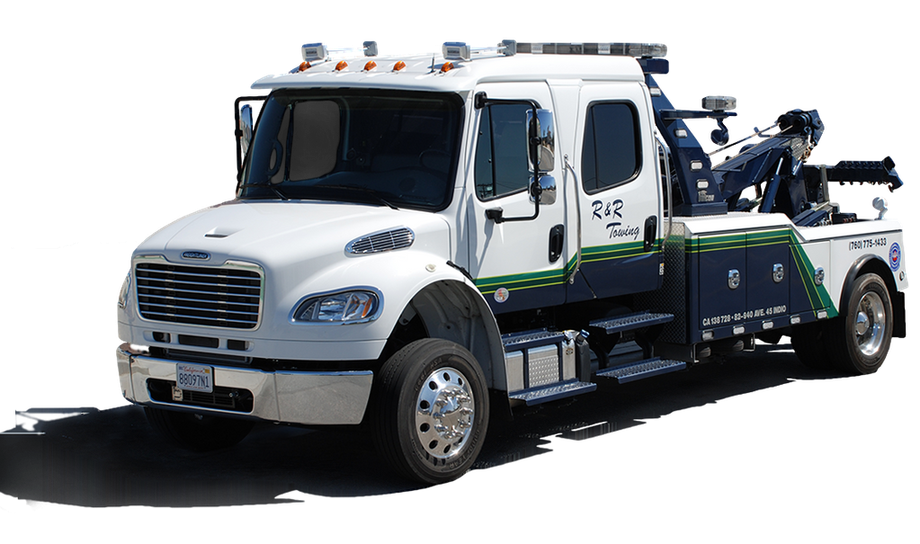 A white and green tow truck is parked on the side of the road.