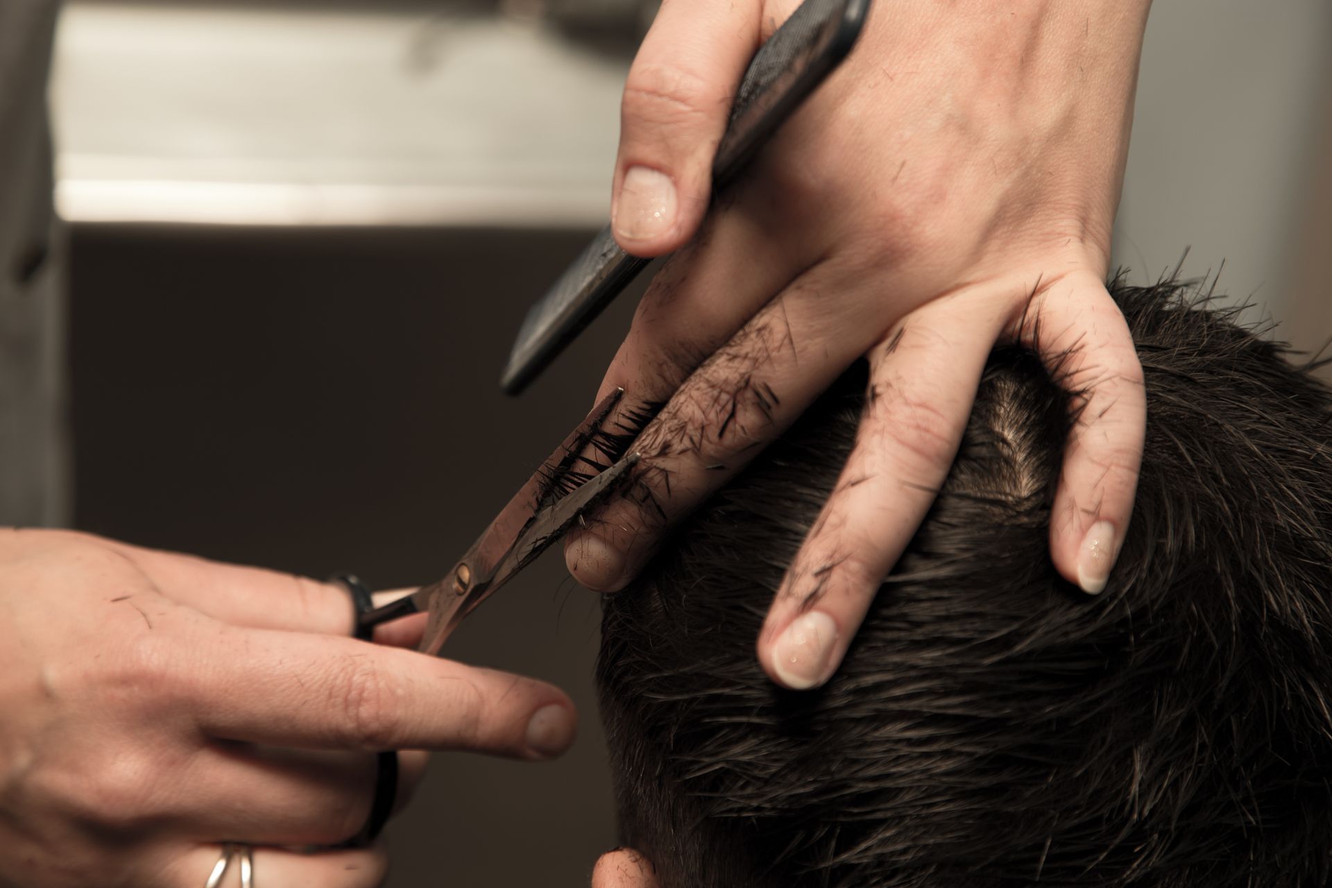 A man is getting his hair cut by a barber