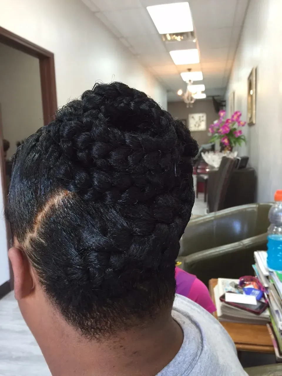 Back of a person’s head with a braided updo in an office hallway chair