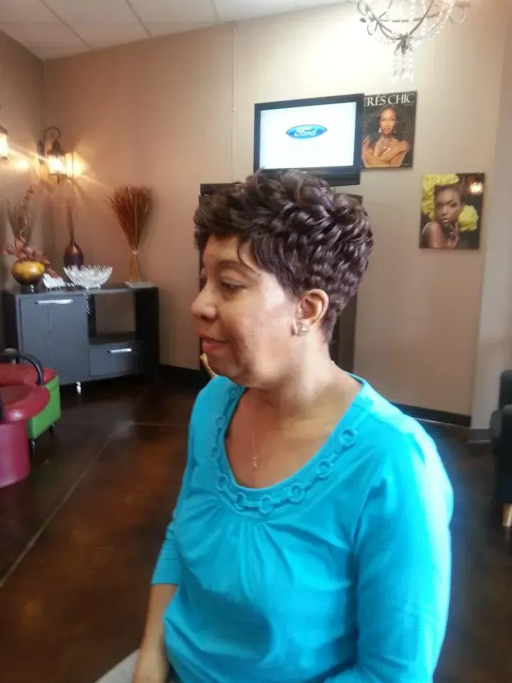 Person in a turquoise top standing in a living room, shown in side profile.