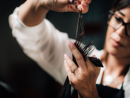 Stylist sectioning wet hair with scissors in a salon