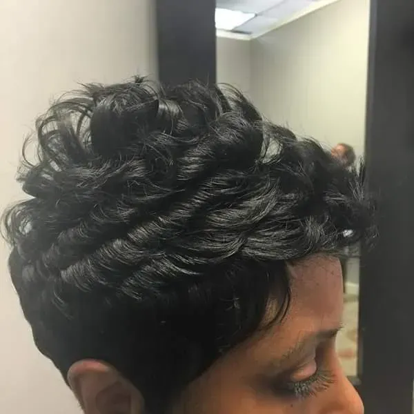 Close-up of a person with dark, curly hair in profile indoors