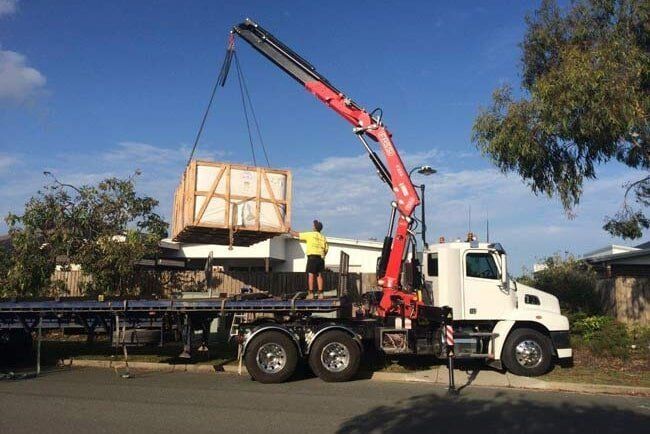 A Row of White Trucks Are Parked in a Grassy Field — Trucking Crane Trucks in Warana, QLD