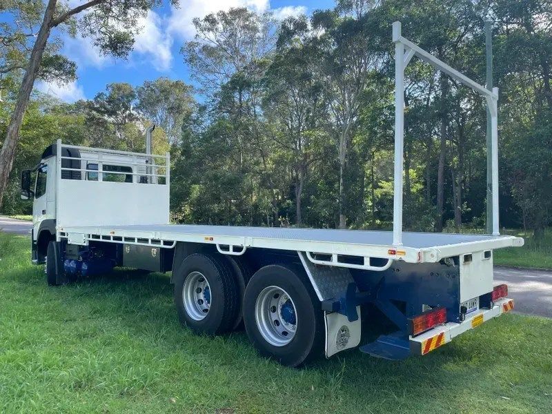 A Row of White Trucks Are Parked in a Grassy Field — Trucking Crane Trucks in Warana, QLD