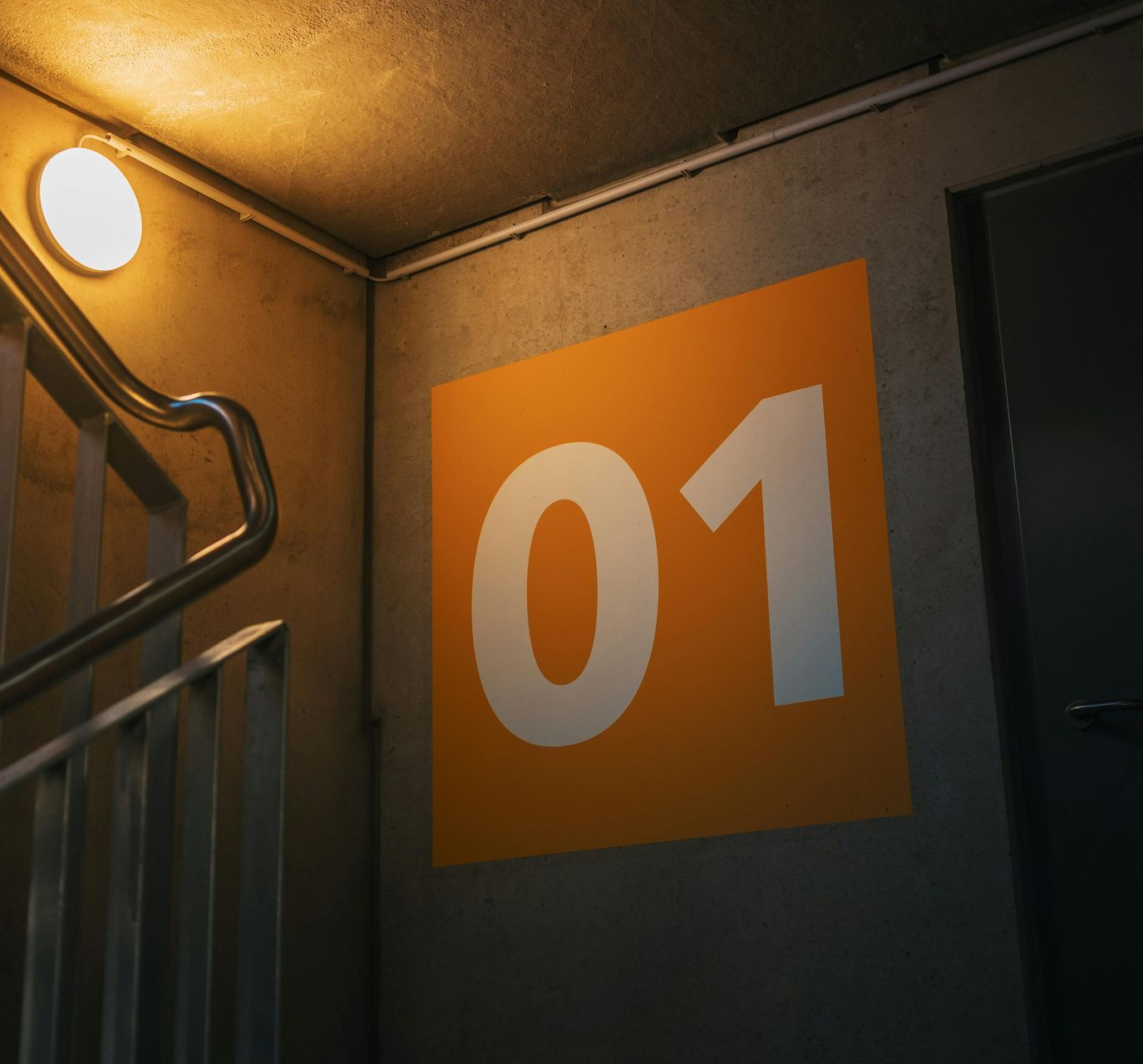 Corner of a stairwell with an orange sign displaying the number