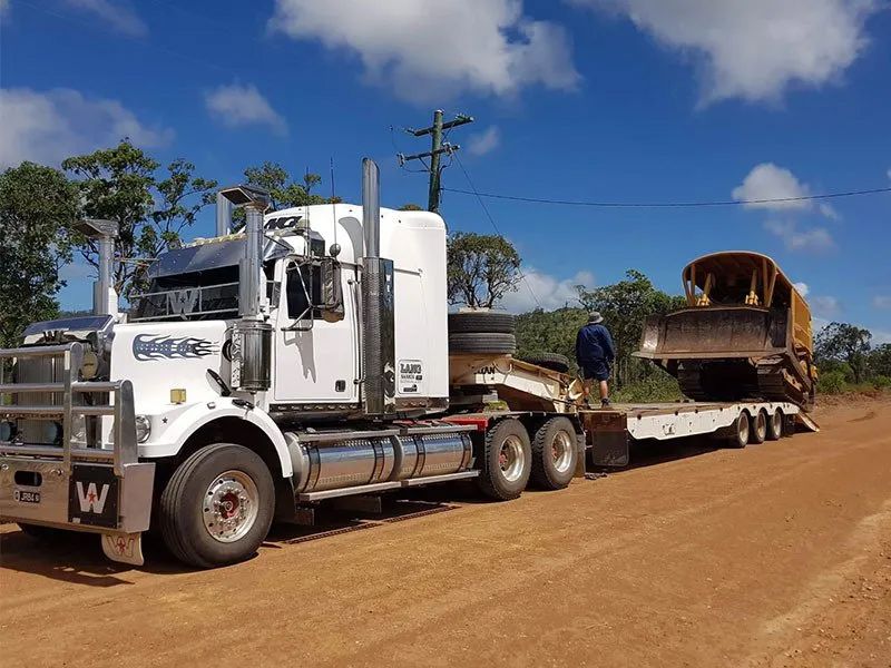 White Truck With Scraper Equipment Loading Onto It — Mike Barlow Earthmoving Pty Ltd in Rockhampton, QLD