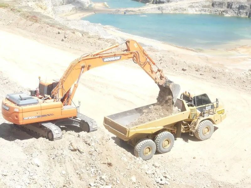 Excavator Is Loading Dirt Into The Dump Truck — Mike Barlow Earthmoving Pty Ltd in Rockhampton, QLD