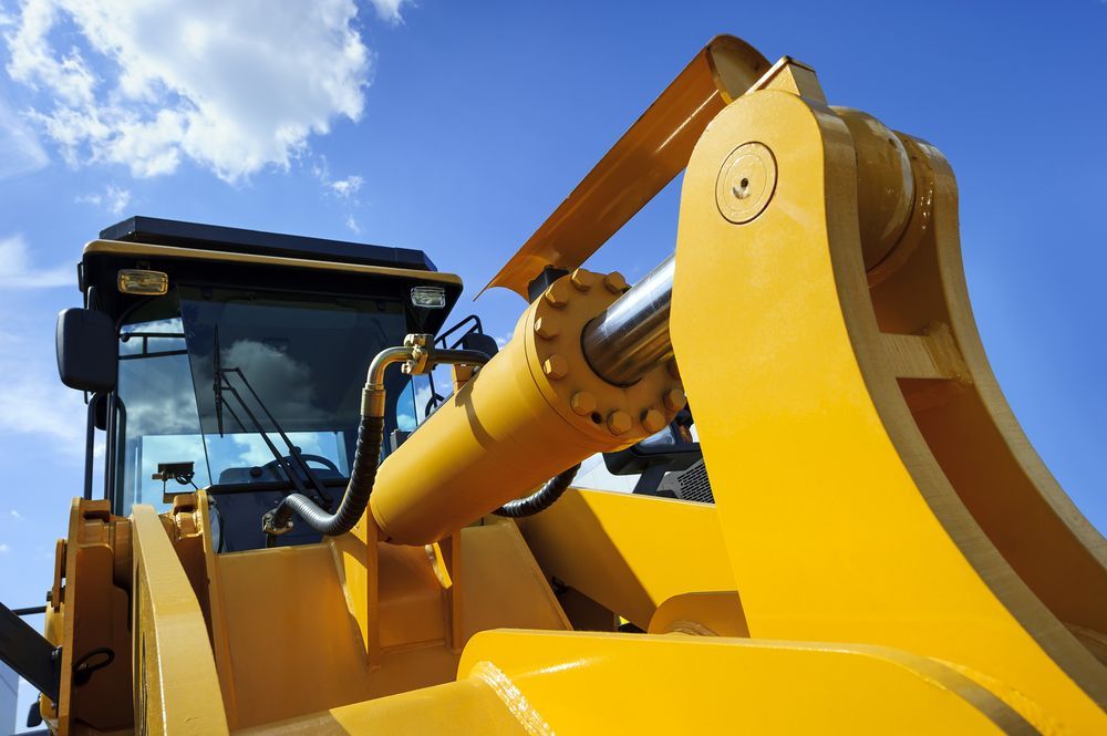 Yellow Excavator Arm Against a Blue Sky — Mike Barlow Earthmoving Pty Ltd in Rockhampton, QLD