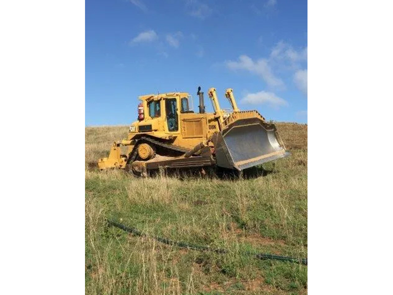 Excavator Equipment Parked In The Grass Field — Mike Barlow Earthmoving Pty Ltd in Rockhampton, QLD