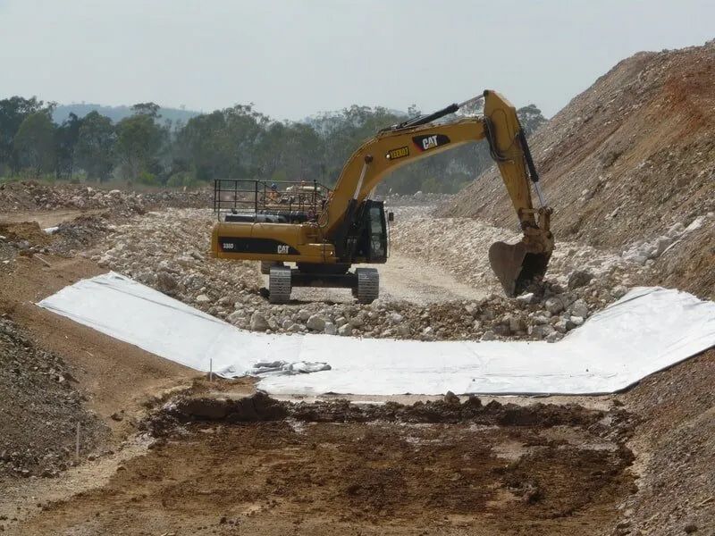 Yellow Bulldozer Clearing Stones For The Road Construction — Mike Barlow Earthmoving Pty Ltd in Rockhampton, QLD