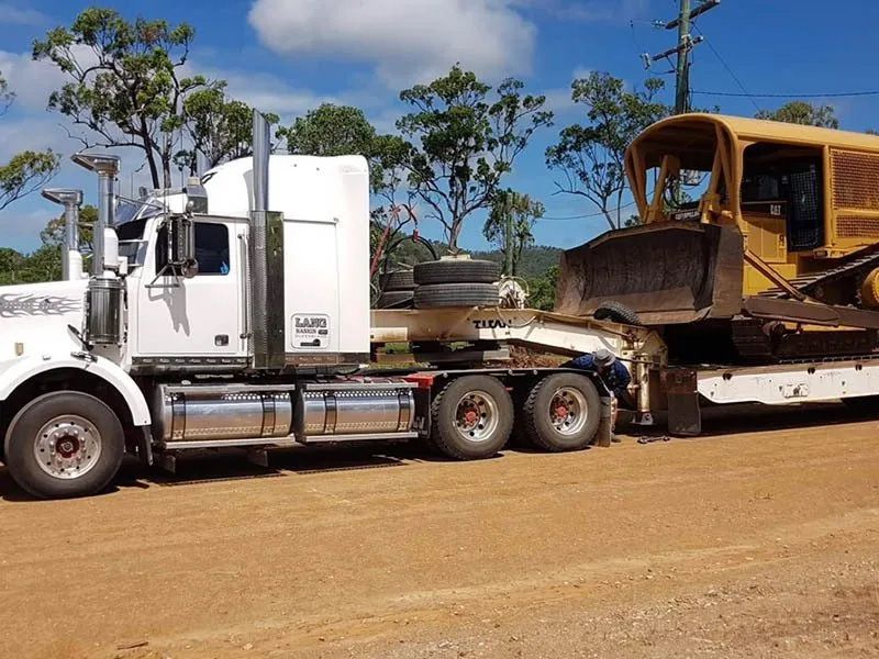 White Semi Truck Moving The Bulldozer On The Trailer — Mike Barlow Earthmoving Pty Ltd in Rockhampton, QLD