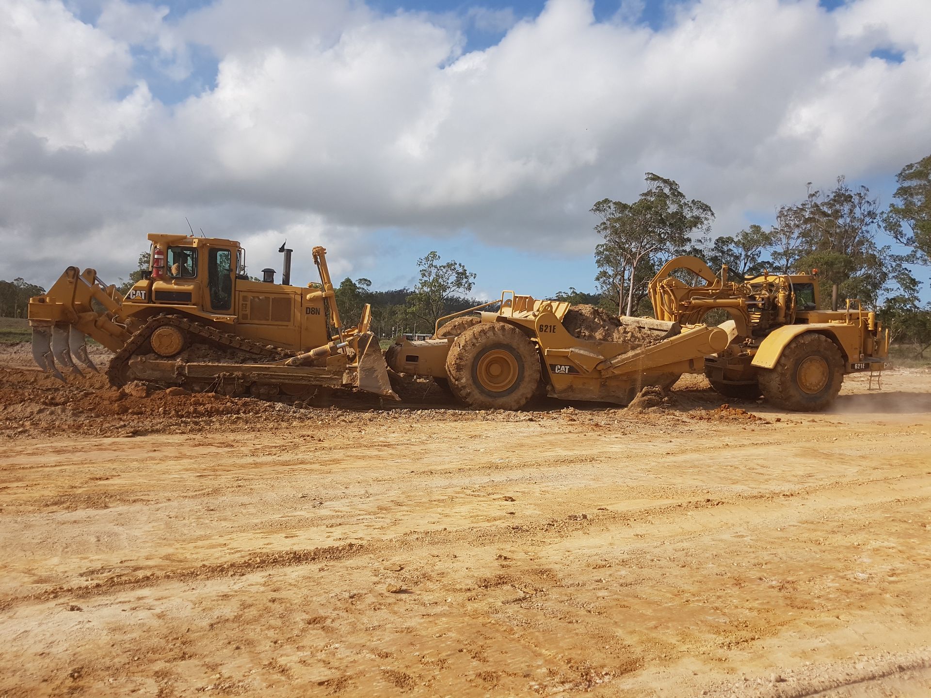 A White Truck Is Parked on A Construction Site Next to A Bulldozer — Mike Barlow Earthmoving Pty Ltd in Rockhampton, QLD