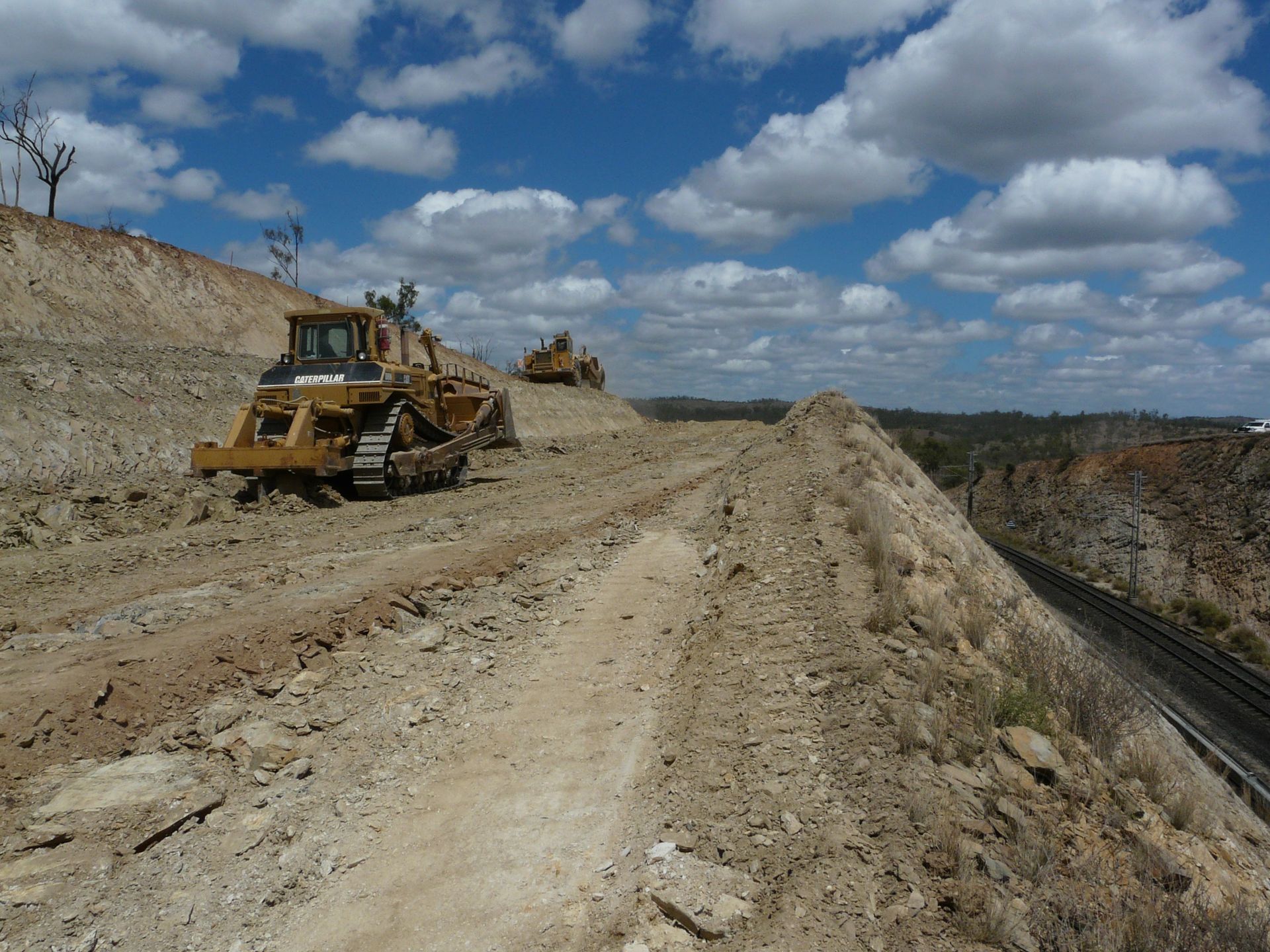 A Bulldozer Is Moving Dirt on A Construction Site — Mike Barlow Earthmoving Pty Ltd in Gladstone, QLD