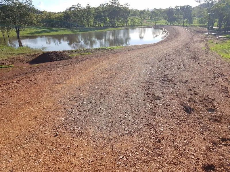 Rough Dirt Road With Lake Beside It — Mike Barlow Earthmoving Pty Ltd in Rockhampton, QLD