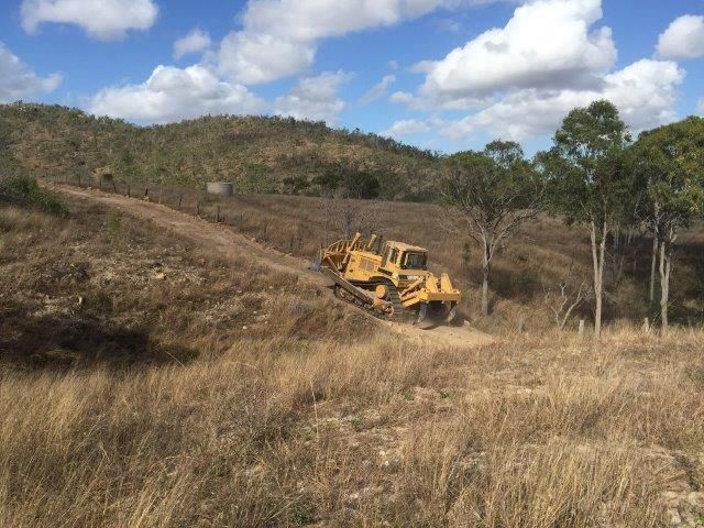 Excavator Driving Through The Mountain On The Dirt Field — Mike Barlow Earthmoving Pty Ltd in Rockhampton, QLD