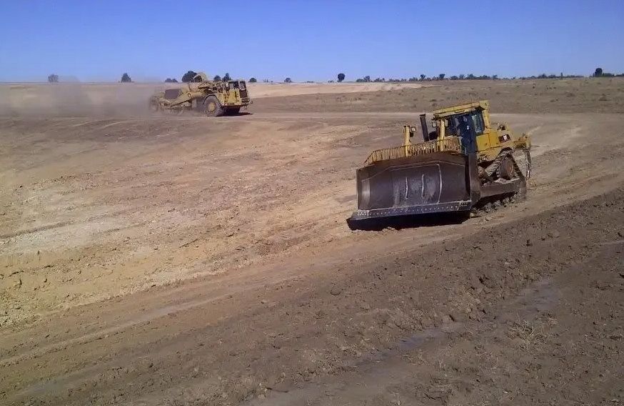 Two Bulldozers Are Working on A Dirt Road — Mike Barlow Earthmoving Pty Ltd in Rockhampton, QLD